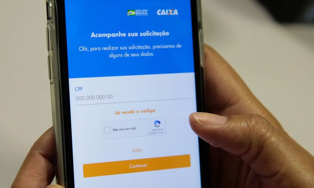 Manuseio de aplicativo da Caixa Econômica Federal em celular