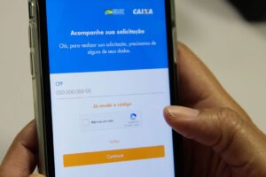 Manuseio de aplicativo da Caixa Econômica Federal em celular