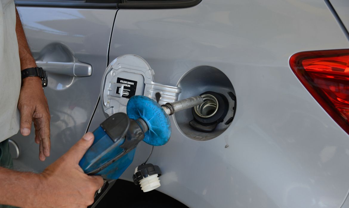 frentista abastece carro com gasolina.