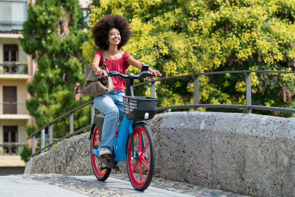 Mulher negra pedala tranquilamente enquanto cruza uma ponte