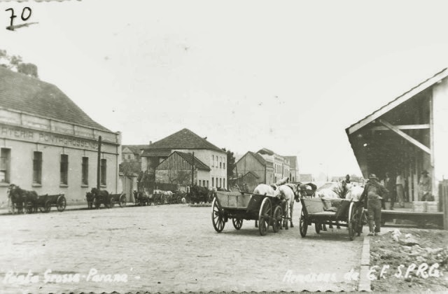 Carroceiros estacionados na Rua Benjamin Constant, em Ponta Grossa. Possivelmente nos anos 1930. Ao fundo, a Hervateria Pontagrossense.