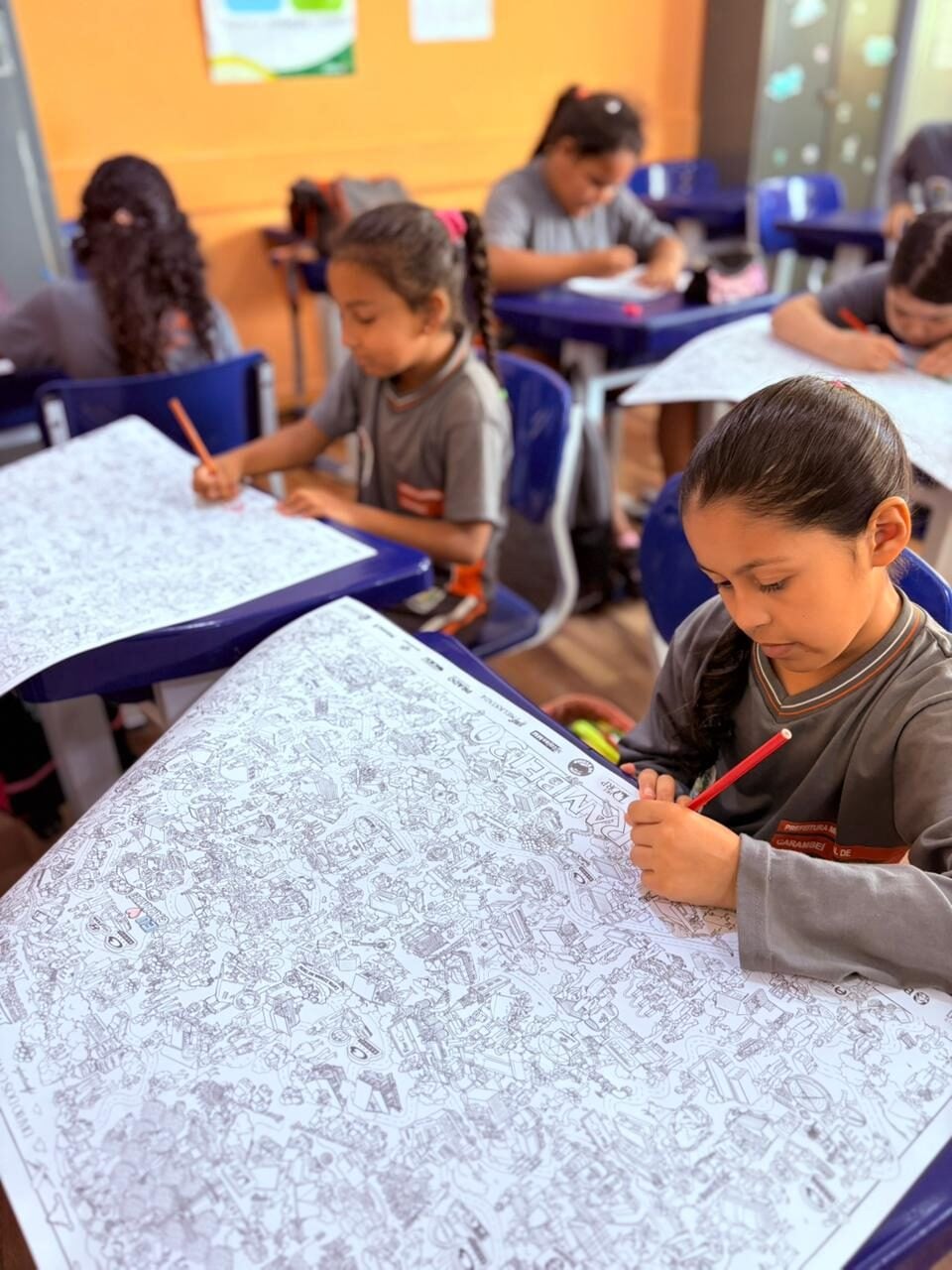 Crianças pintando o mapa do Vamos Pintar Carambeí