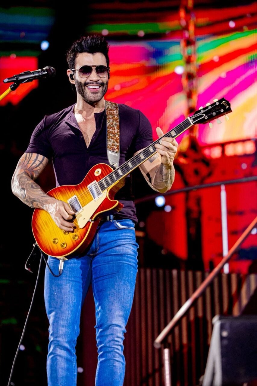 Gusttavo Lima toca violão em show. Cantor apresentar-se-á na München em Ponta Grossa.