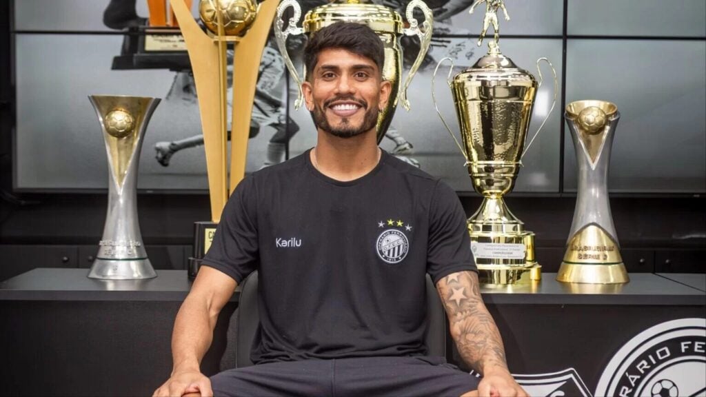 Indio, do Operário, posa diante de troféus.