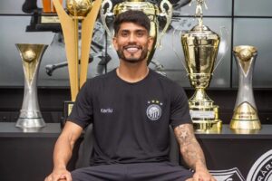 Indio, do Operário, posa diante de troféus.