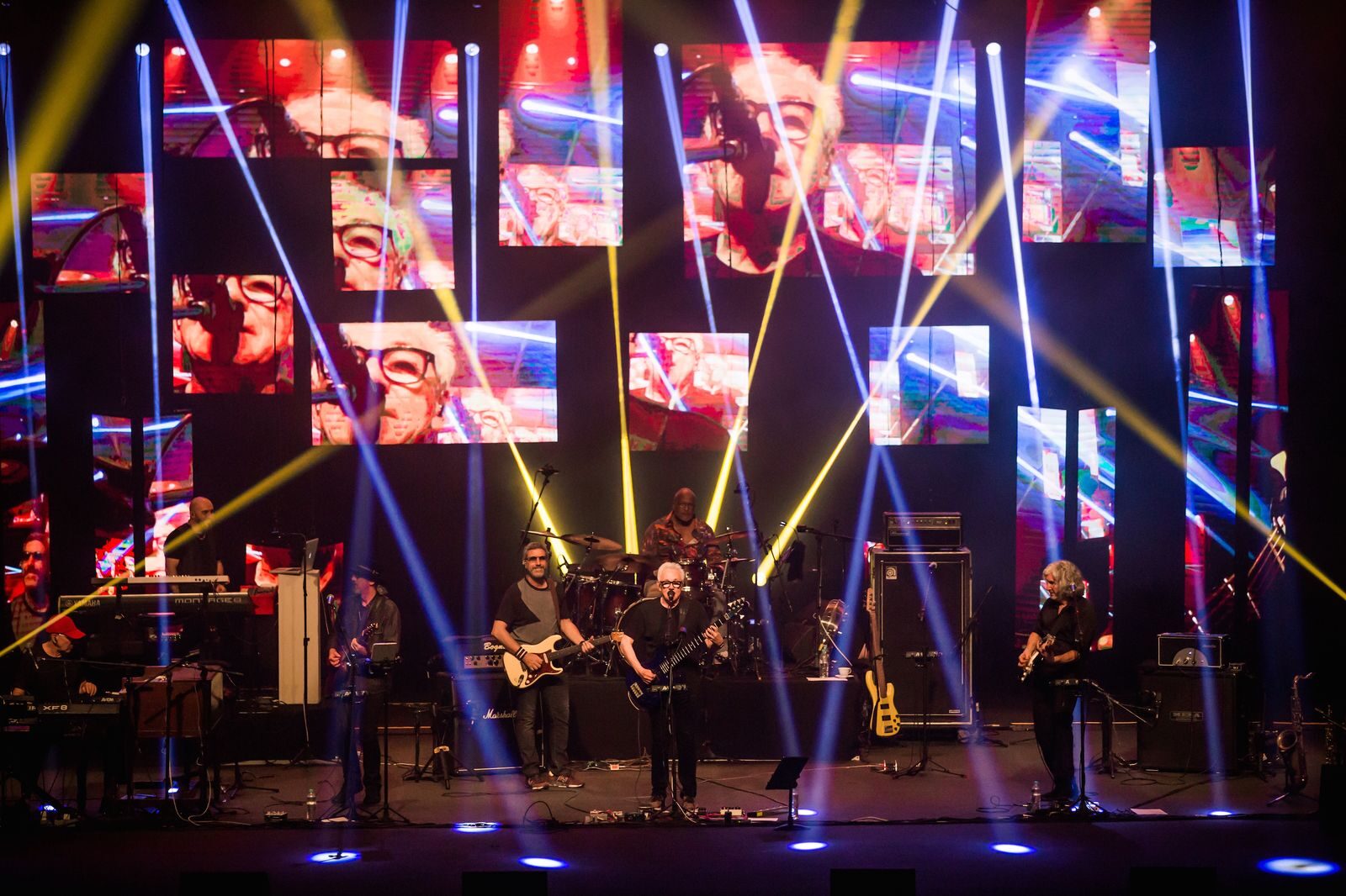 Músicos da Dire Straits Legacy em palco iluminado