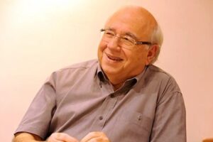 Escritor falecido Luis Fernando Veríssimo em fundo tons pasteis.
