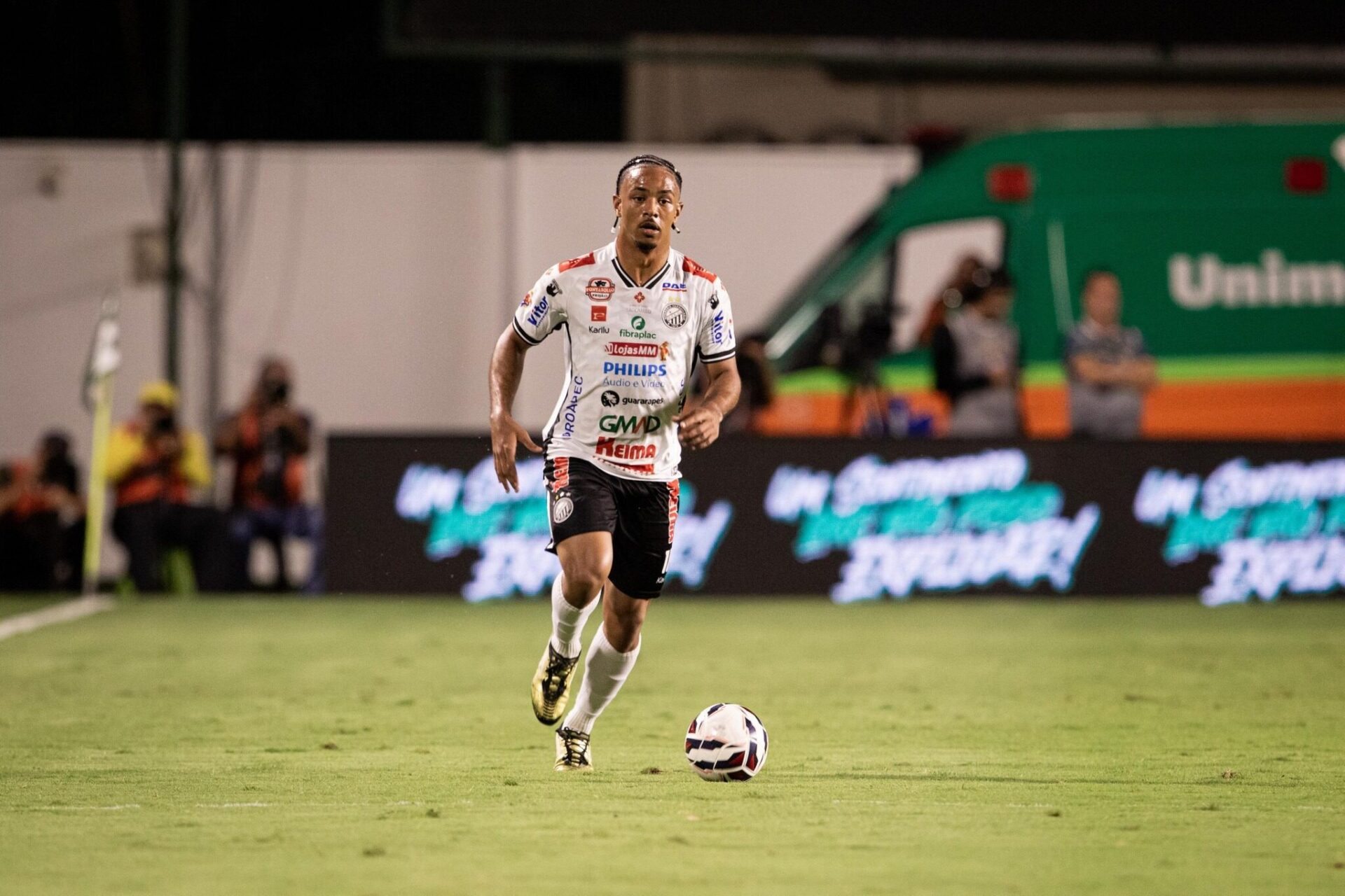 Atleta do Operário vestindo uniforme preto e branco conduzindo a bola