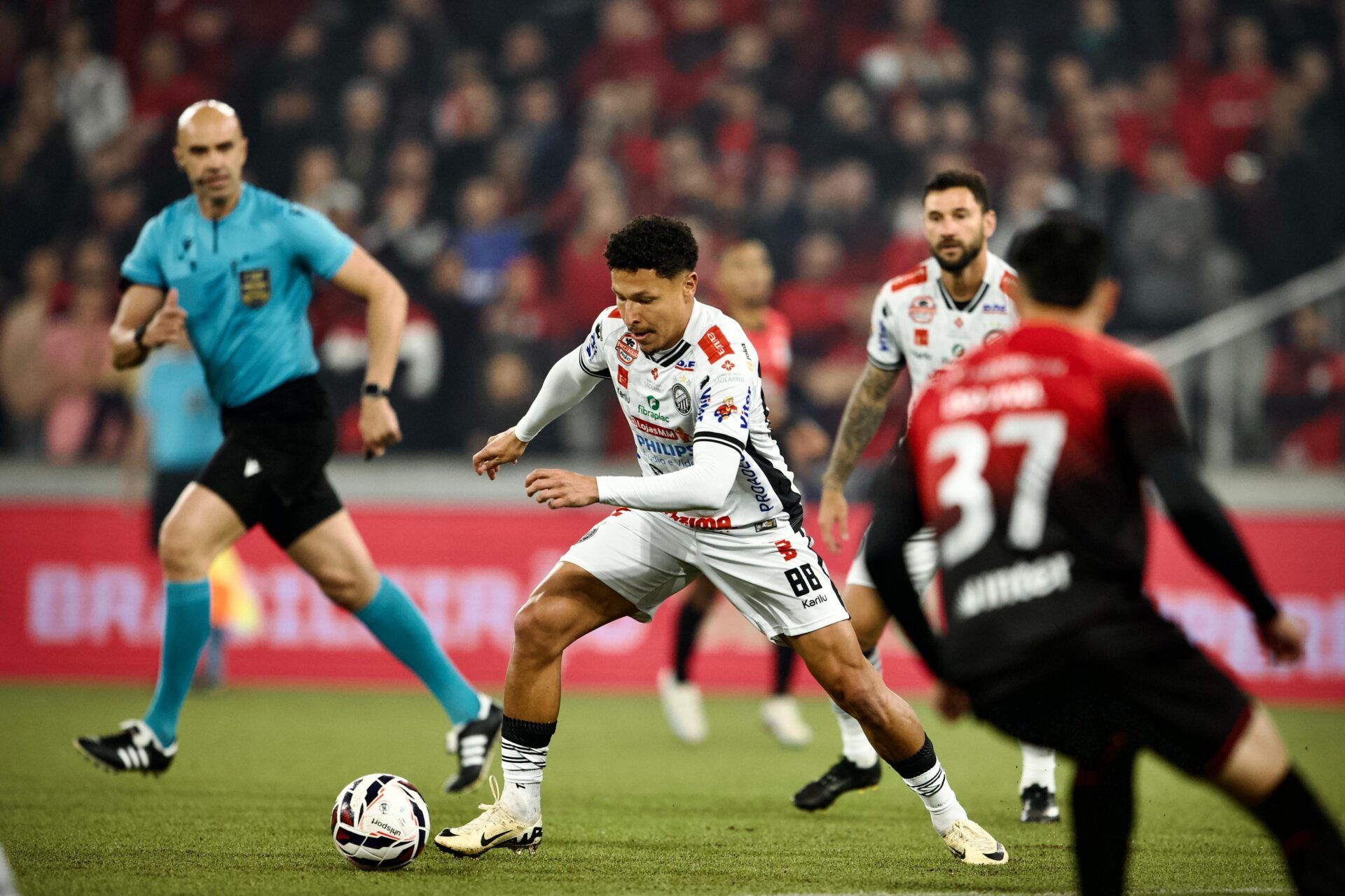 Jogador do Operário diante de adversários do Athletico
