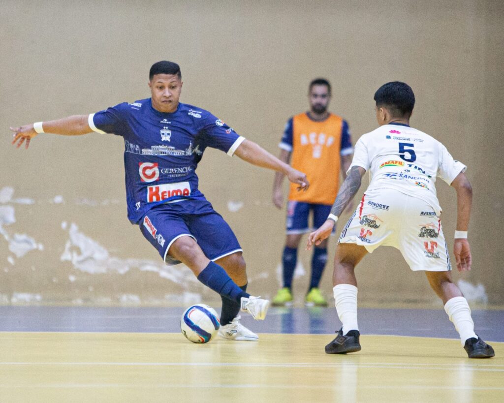 Jogador da ACGF em azul dribla adversário em foto que ilustra pauta dos Jogos Abertos do Paraná