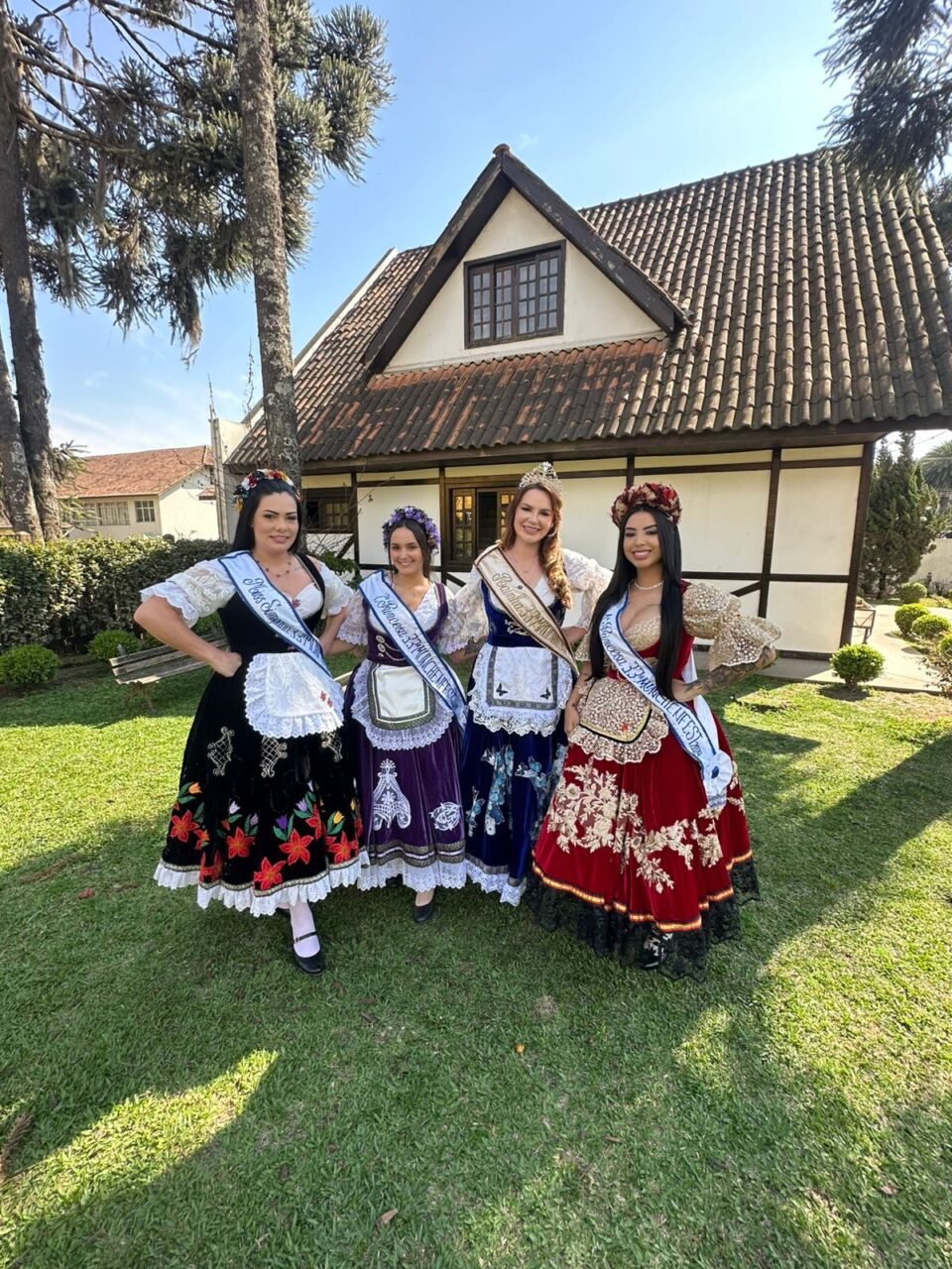 Majestades da edição anterior da Münchenfest diante de edificação campesina