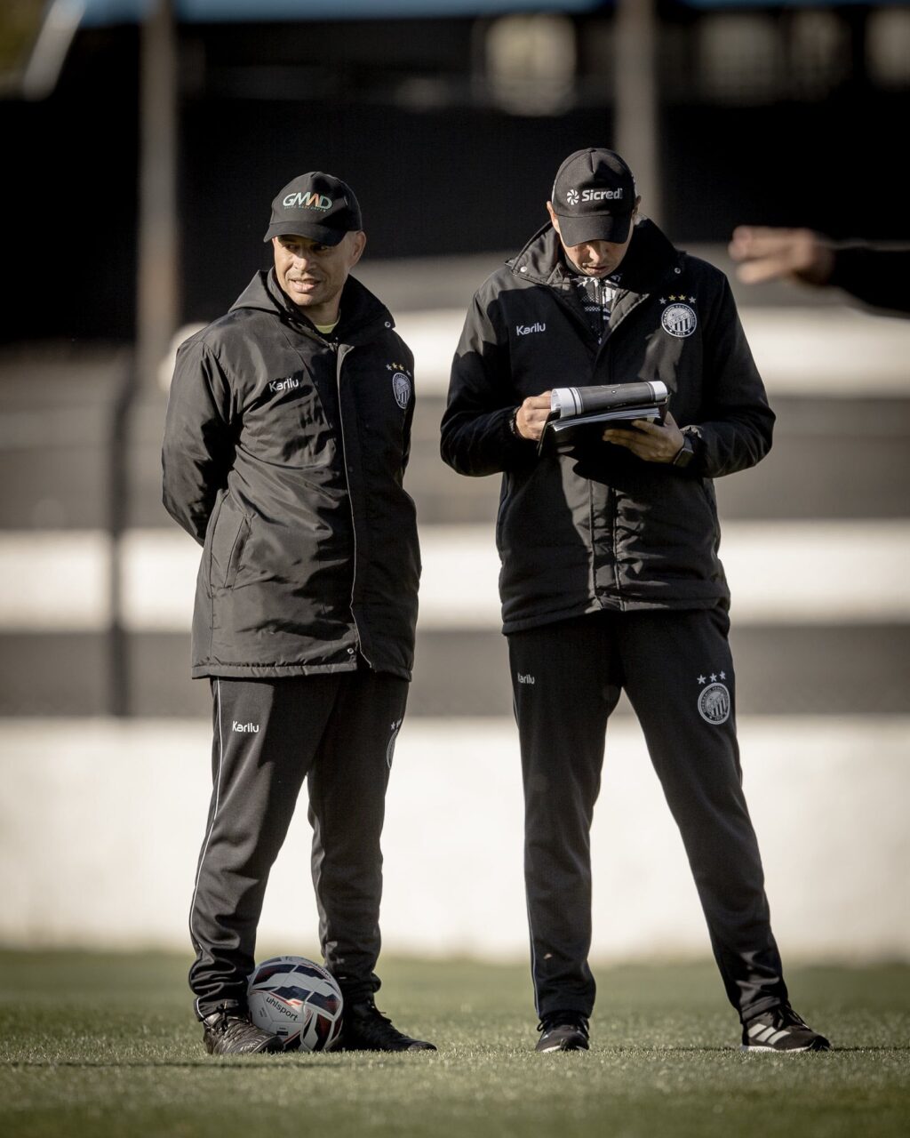 Alex e assistente técnico em uniformes do Operário Ferroviário no gramado.