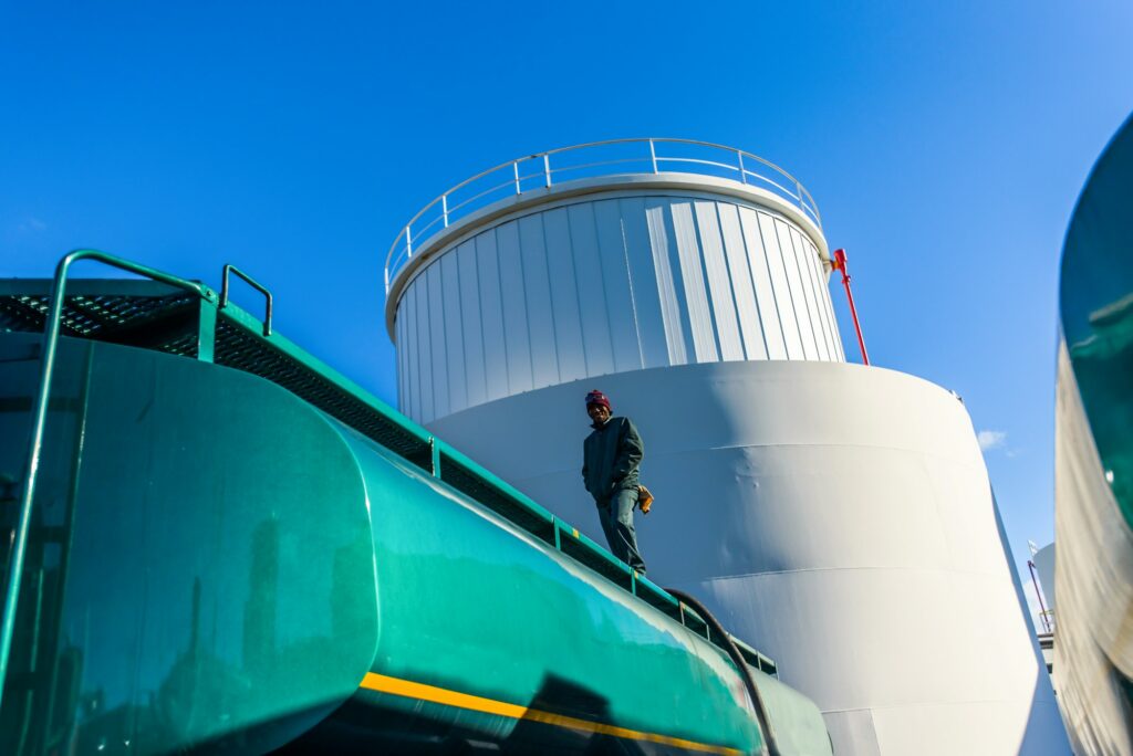 Caminhão tanque parado próximo a um silo de biocombustível