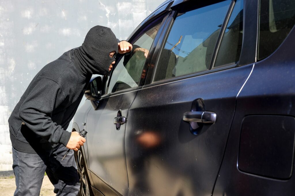 Homem suspeito e mascarado olha pelo vidro do carro