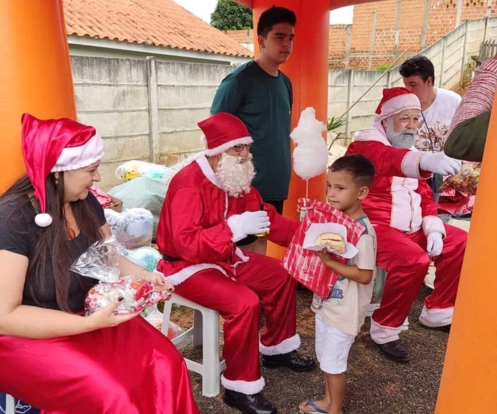Criança recebendo presente do Papai Noel no Natal Solidário do Costa Rica