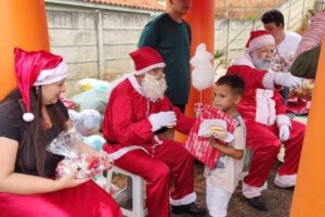 Criança recebendo presente do Papai Noel no Natal Solidário do Costa Rica