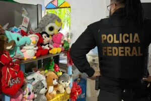 Policial federal em operação contra abuso sexual de crianças e adolescentes, ao lado de ursinho de pelúcia