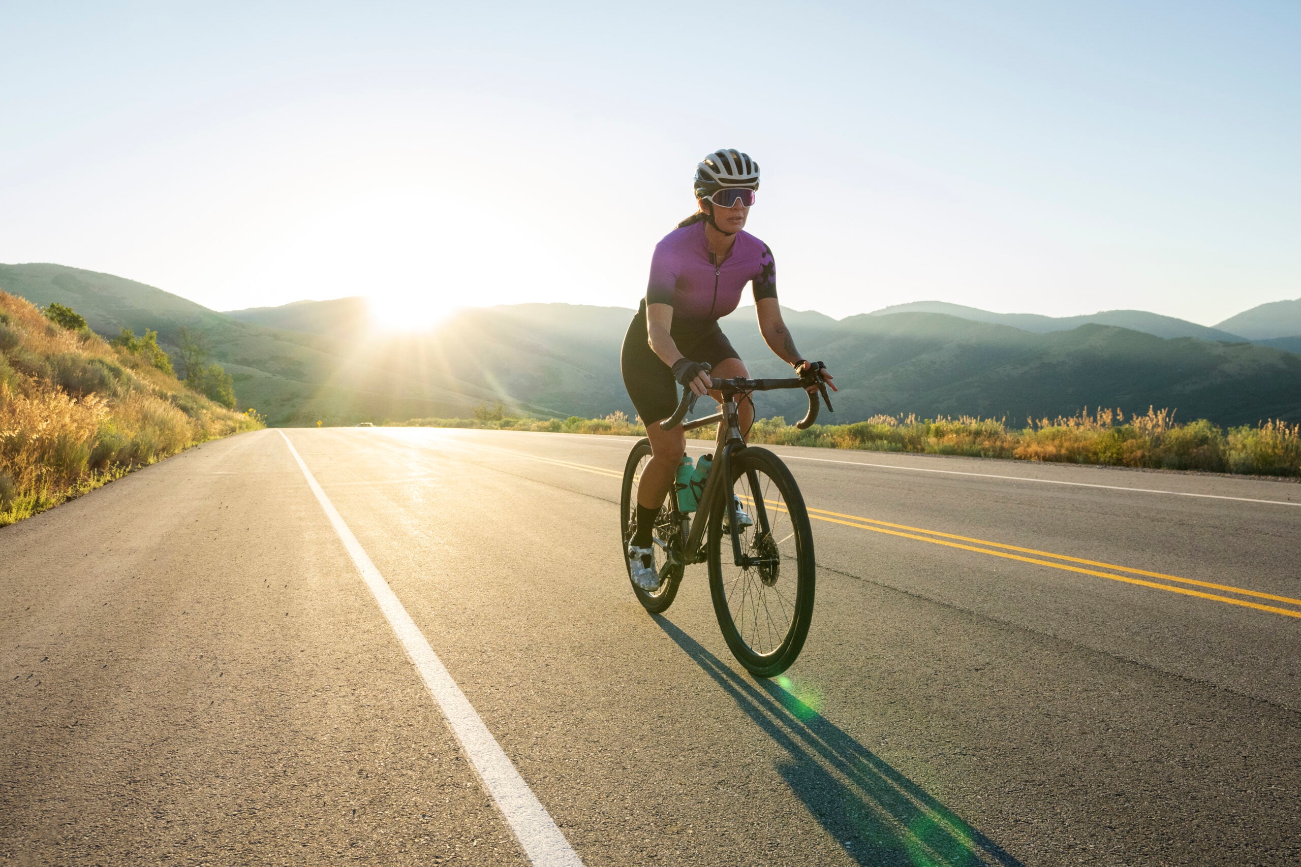 Mulher em bicicleta percorrendo a estrada.
