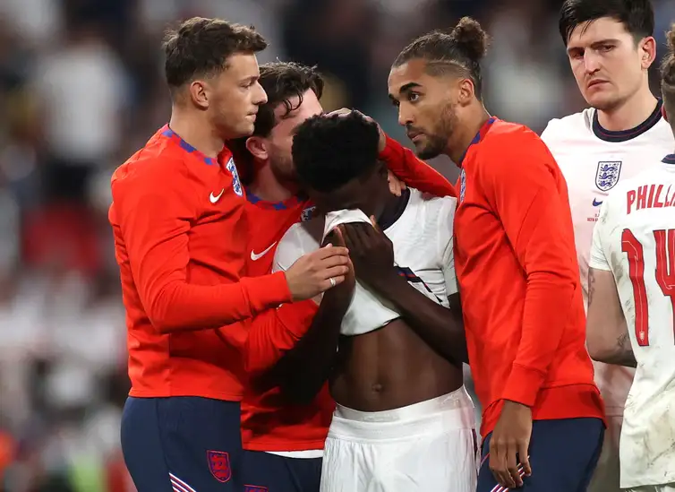 Pool via REUTERS/Carl Recine/Direitos Reservados Bukayo Saka é consolado por colegas de time após derrota da Inglaterra para a Itália na final da Eurocopa em Wembley