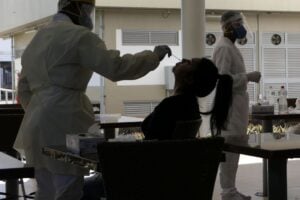 Foto de pessoa passando por procedimento de testagem para covid-19, com uso de cotonete