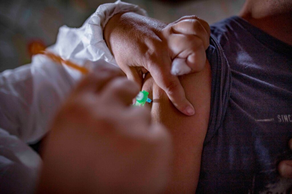 Aplicação de vacina contra a covid-19 em jovem.