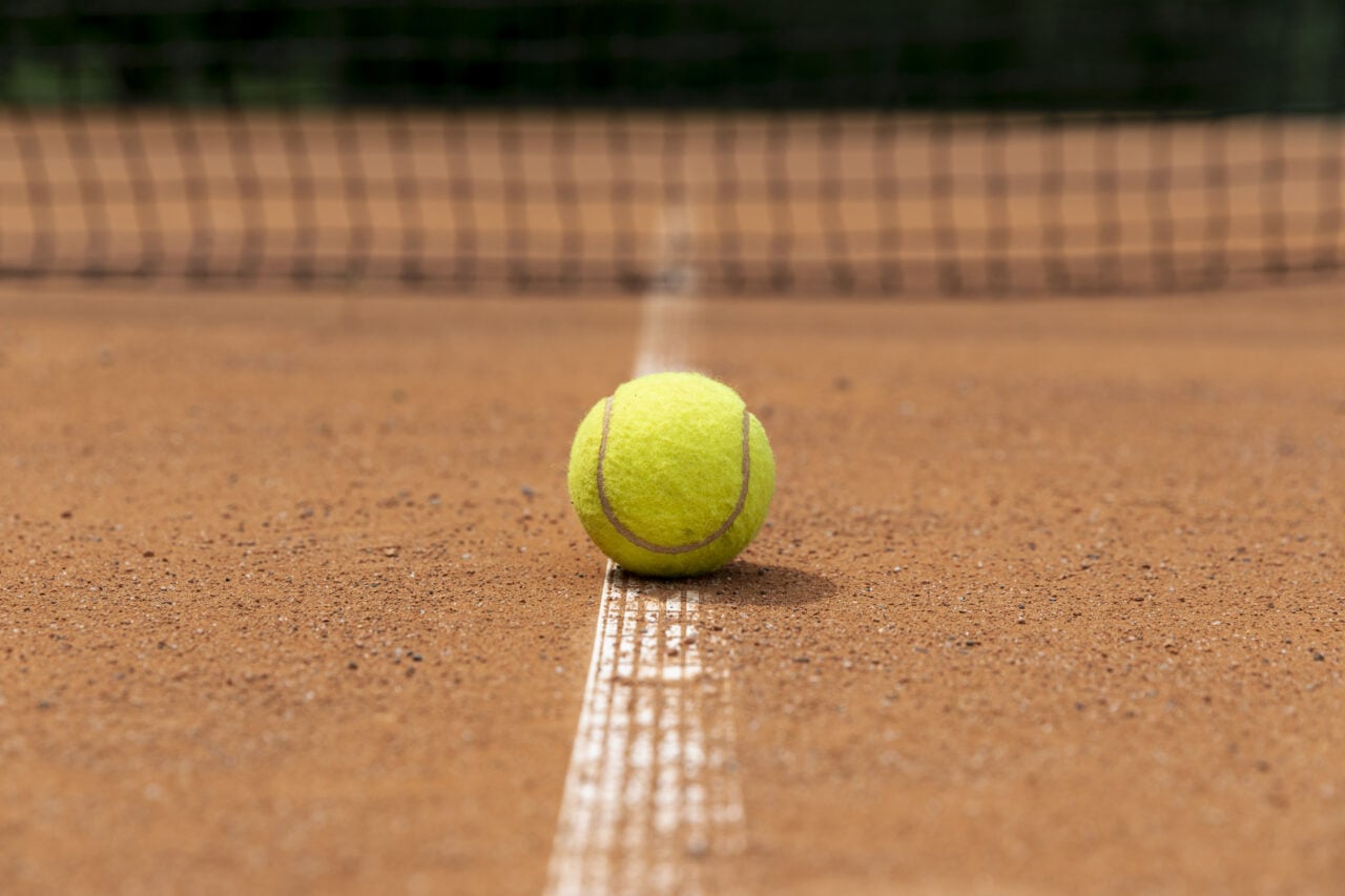 Bola de tênis em quadra de saibro ilustra o Frísia Open de Tênis