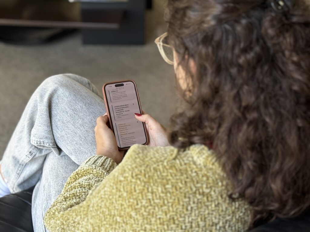 Estudante de costas visualiza tela de celular
