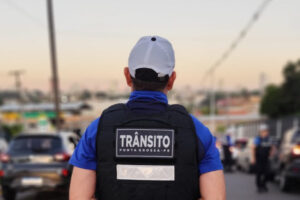 Agente de trânsito de costas observando o movimento da rua