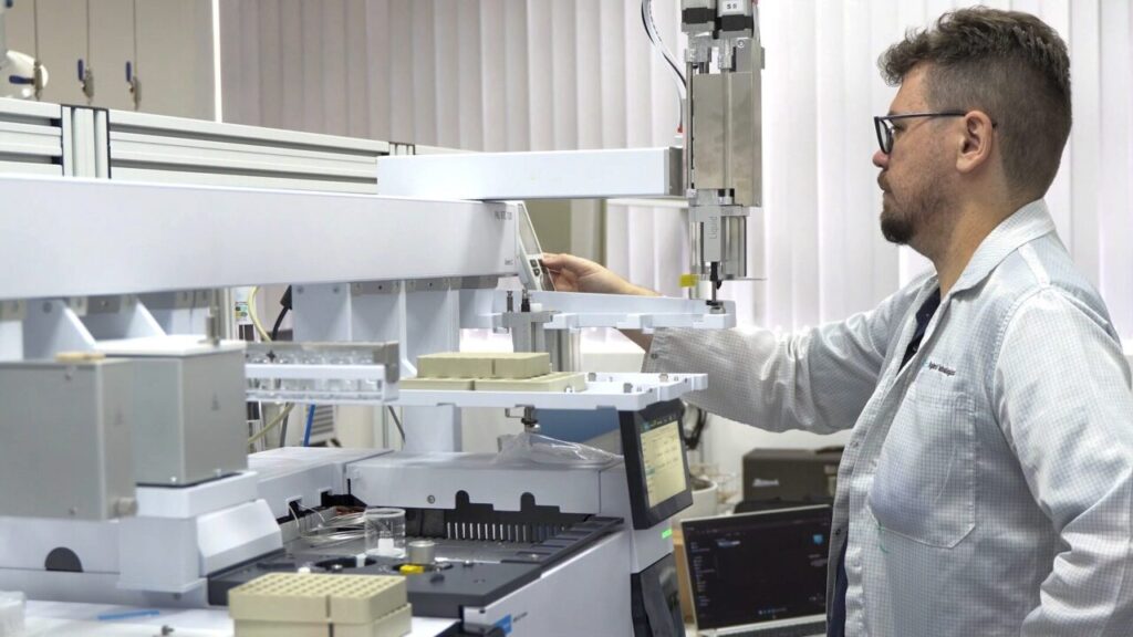 Técnico da Sanepar analisa a qualidade da água, diante de equipamentos de laboratório