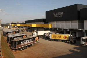 Fachada da fábrica do Grupo Madero, em Ponta Grossa, mostra caminhões da marca estacionados