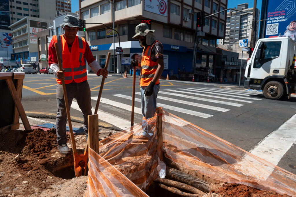 Homens trabalhando na instalação de semáforo na esquina da Rua Balduíno Taques com Avenida Vicente Machado, no Centro de Ponta Grossa