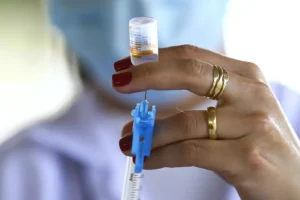 Enfermeira manuseia seringa para aplicação de vacina da covid-19