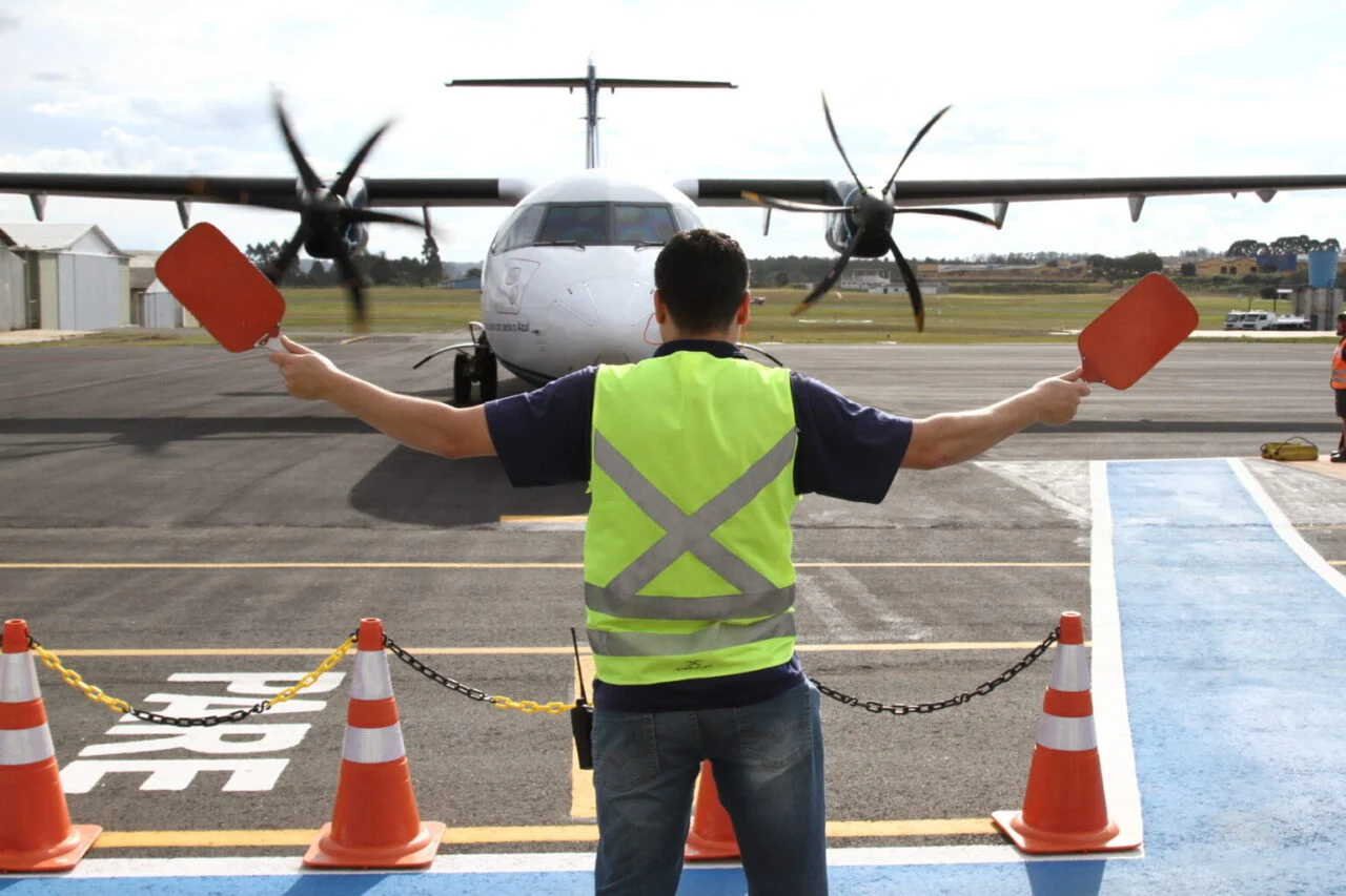 Fiscal sinalizando o taxiamento de um avião no Aeroporto de PG