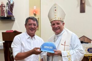 Prefeito de Sengés Gerson Nunes ao lado de Dom Mário, novo Arcebispo de Aparecida, segurando um boné com o nome do município dos Campos Gerais