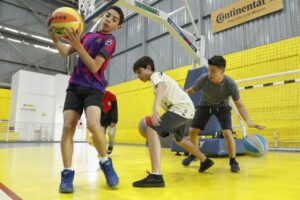 três crianças praticando basquete