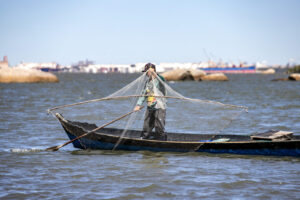 homem retirando rede de pesca do mar
