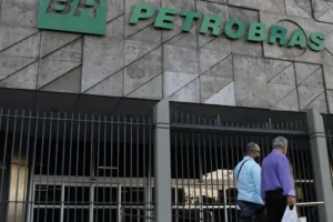 Duas pessoas passando na frente do prédio da petrobras