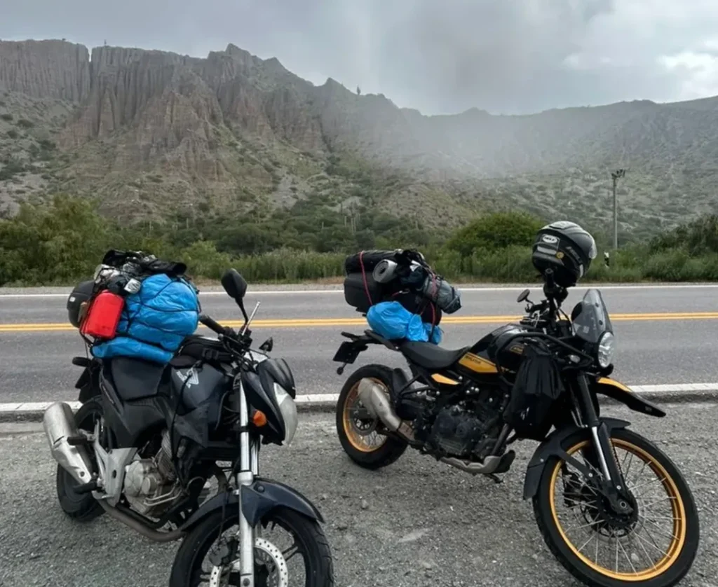 motocicletas estacionadas à beira da rodovia, tendo ao fundo montanhas argentinas