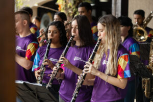 Três mulheres tocando instrumento de sopro durante o World Creativity Day 2025