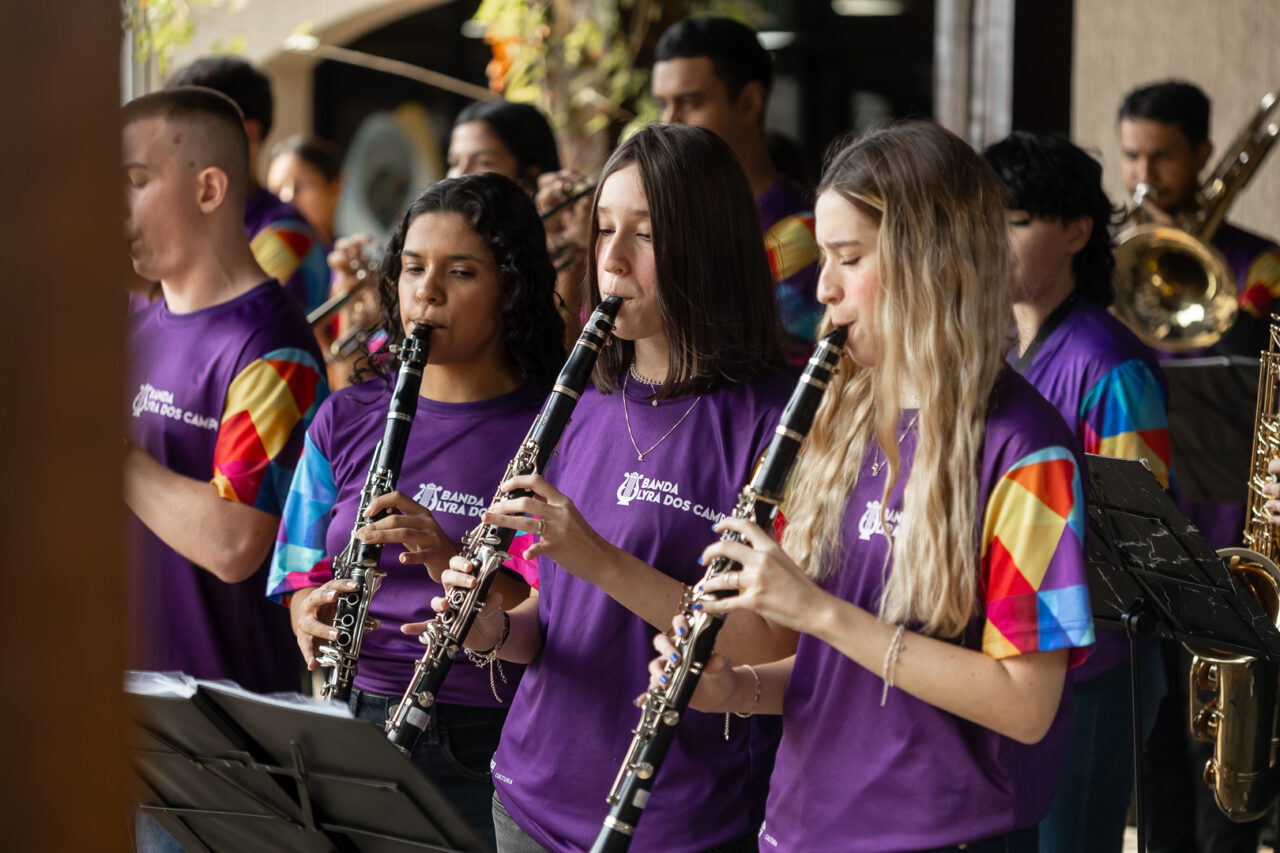 Três mulheres tocando instrumento de sopro durante o World Creativity Day 2025