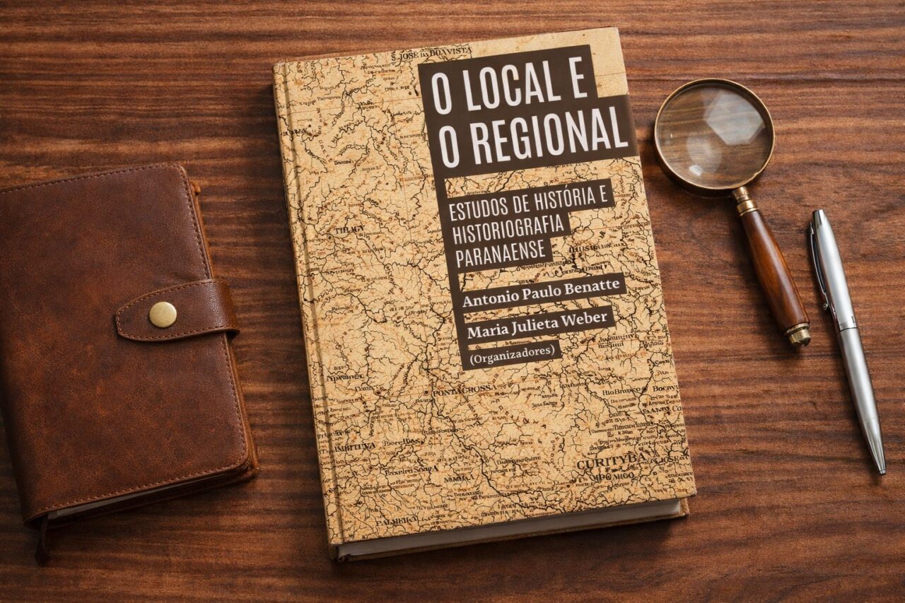 Livro O Local e o Regional sobre mesa de madeira