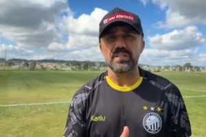 Técnico do Operário, Luizinho Lopes, em vídeo no CT UEPG, com o gramado ao fundo e céu azul com nuvens acima
