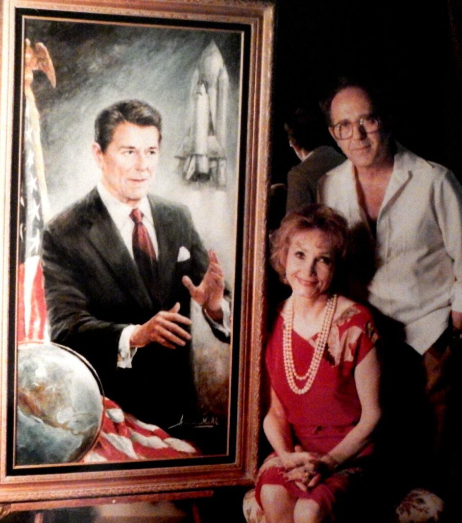 Casal Makk em 1984 com retrado de Ronald Reagan