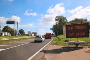 Rodovia com veículos e uma placa de orientação