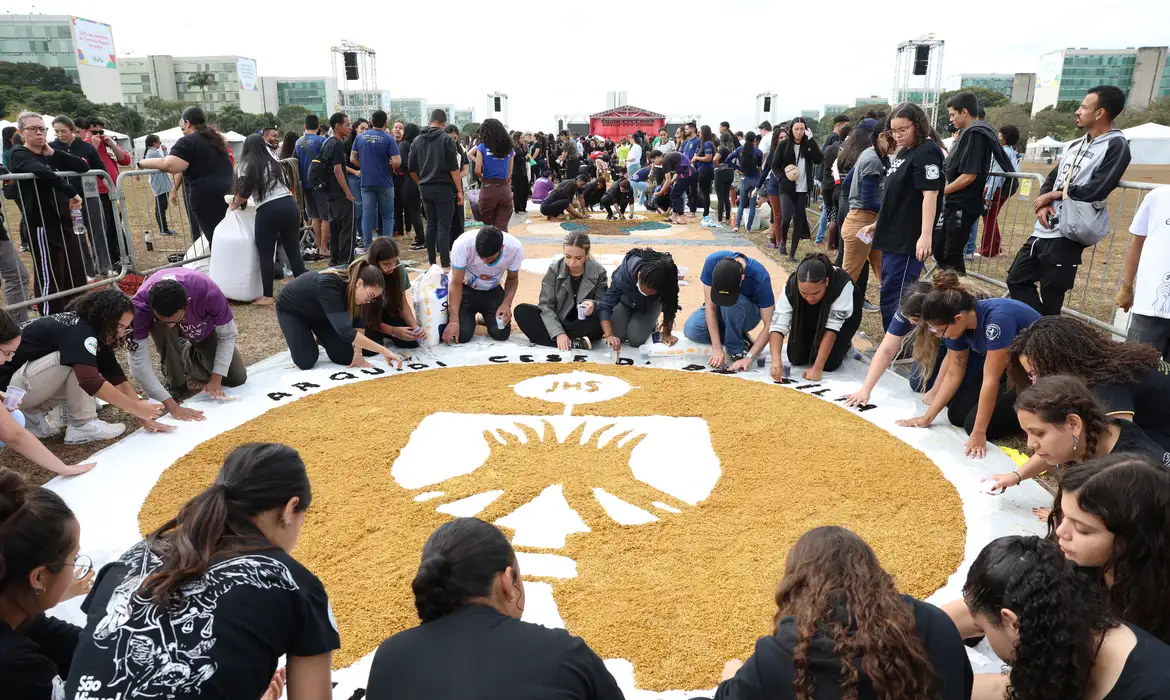 Pessoas confeccionando um tapete para o Corpus Christ