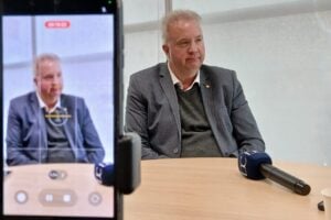 Presidente do Sicredi, Marcio Zwierewicz, em entrevista para o Diário dos Campos, na Sede Regional da Cooperativa em Ponta Grossa. Descrição da imagem: Câmera, em primeiro plano, filmando Marcio Zwierewicz concedendo entrevista, com um microfone do DC em cima da mesa.