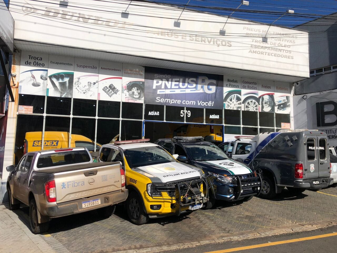 Fachada da Simão Pneus, empresa de Ponta Grossa, com veículos estacionados em frente