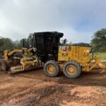 Caminhão de obras sob rua de terra