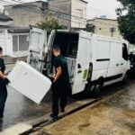 Equipe da Circulare carregando um eletrodoméstico até a van, durente serviço gratuito de coleta de eletrodomésticos a domicílio no Brasil