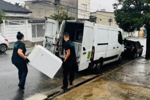 Equipe da Circulare carregando um eletrodoméstico até a van, durente serviço gratuito de coleta de eletrodomésticos a domicílio no Brasil